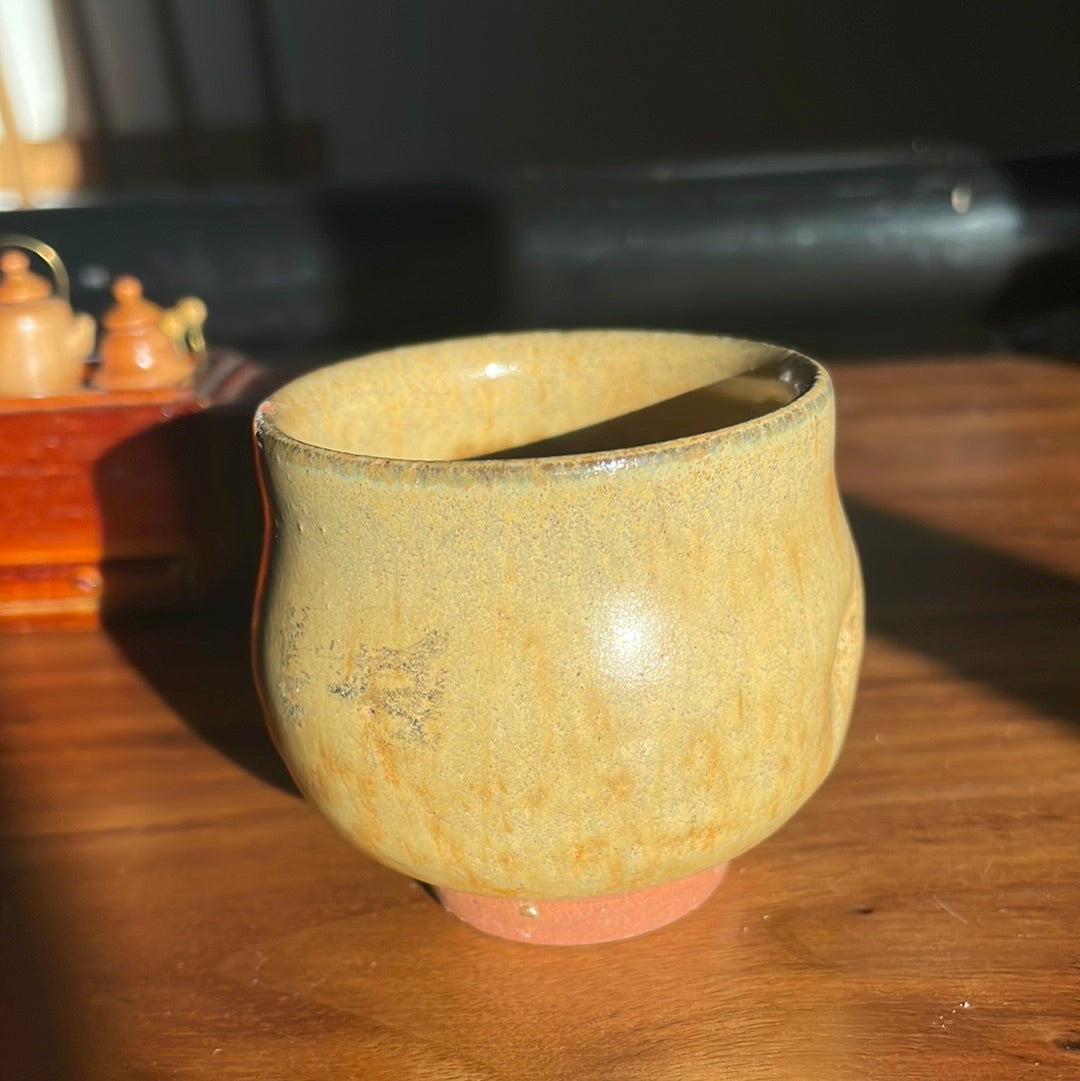 Handmade orange-sage guinomi with thumb indentation