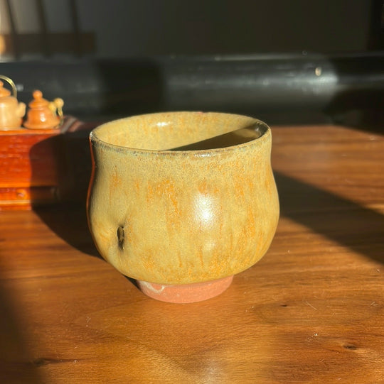 Handmade orange-sage guinomi with thumb indentation